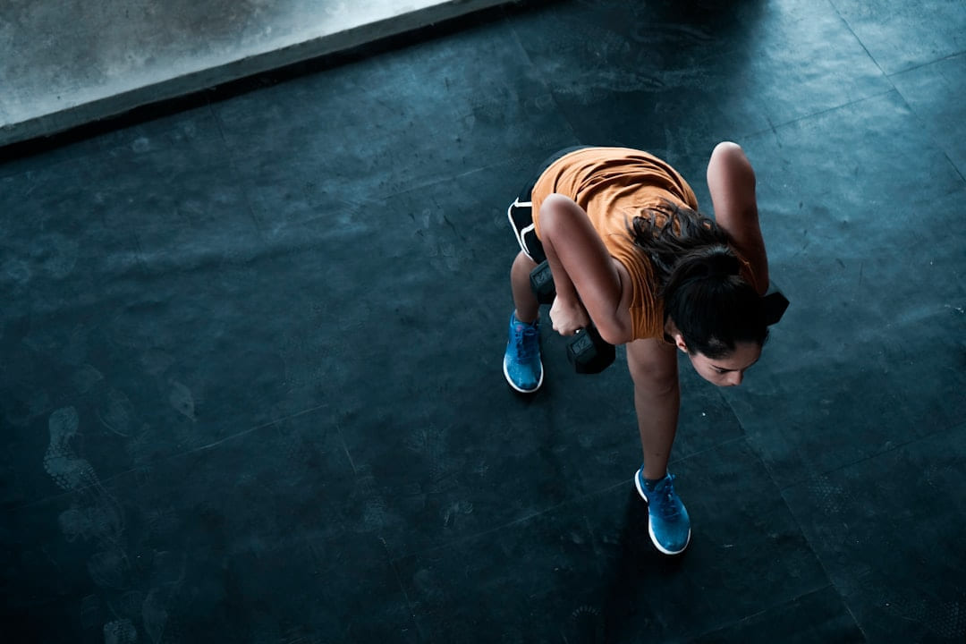 woman in orange top exercising indoors on First Rep Forward