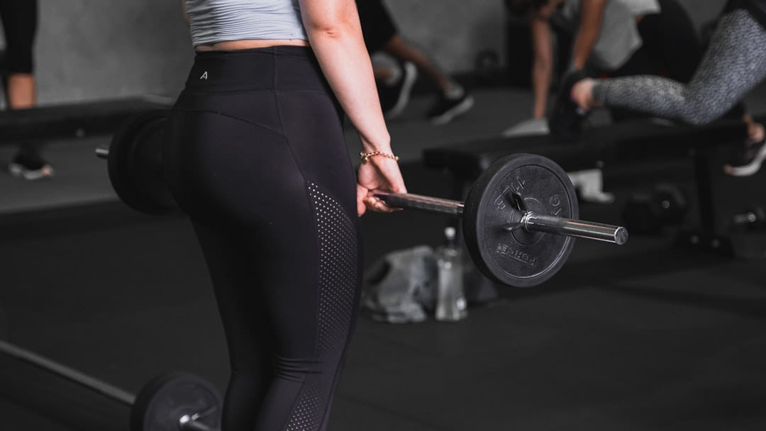 a woman lifting a barbell in a gym on First Rep Forward