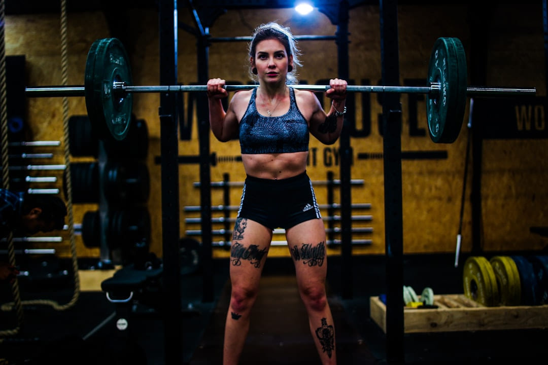 woman standing and carrying barbell on First Rep Forward