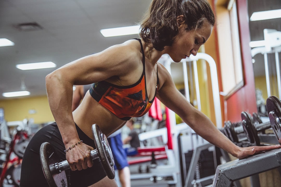 woman seriously performing gym exercise on First Rep Forward