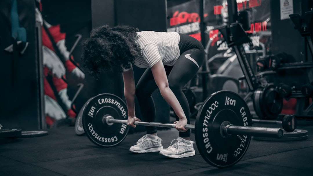 a woman lifting a barbell in a gym on First Rep Forward