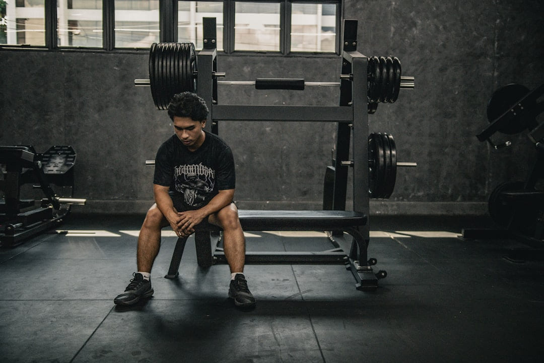 A man sitting on a bench in a gym on First Rep Forward