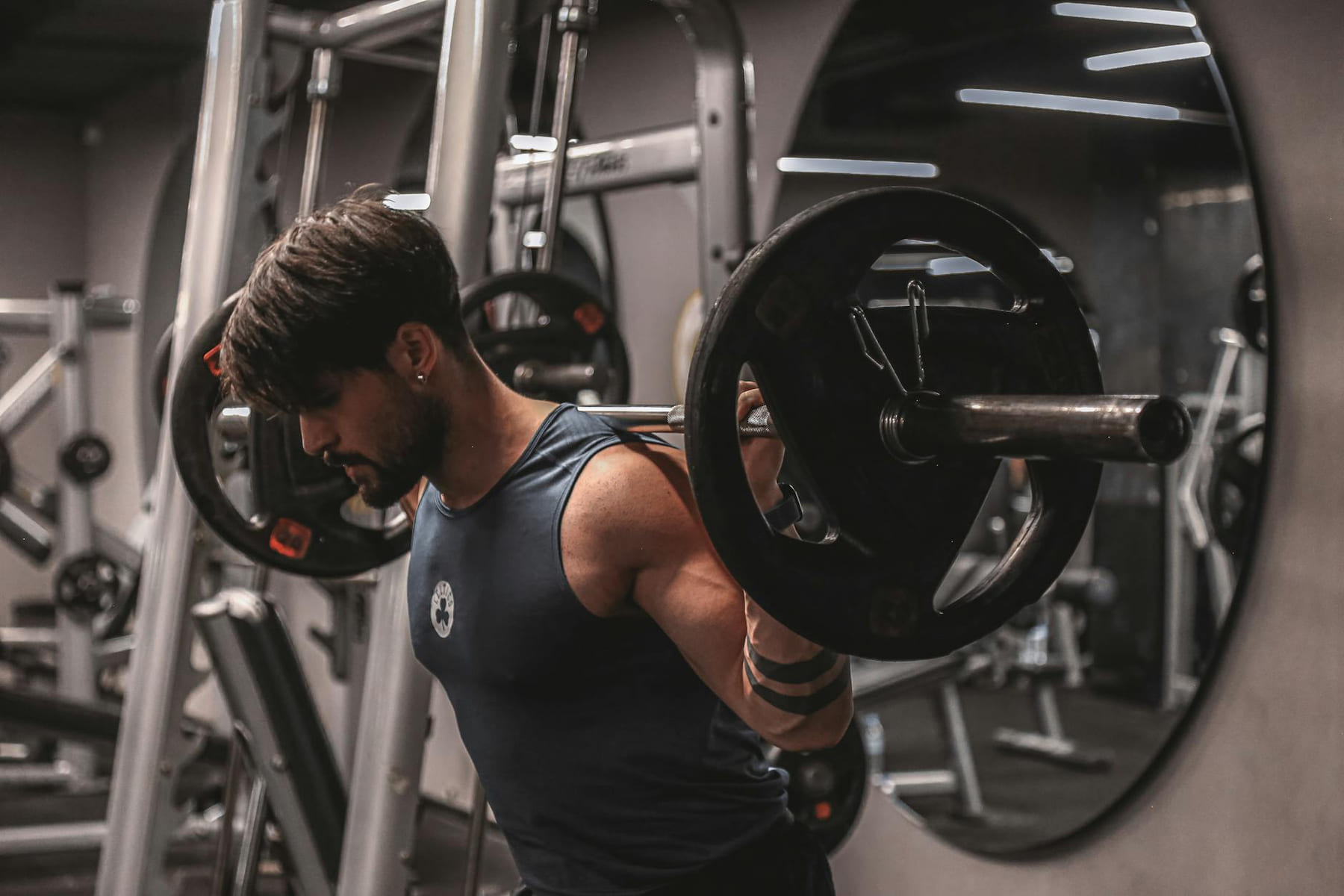 Muscular man lifting weights in a modern gym, focusing on strength training. on First Rep Forward