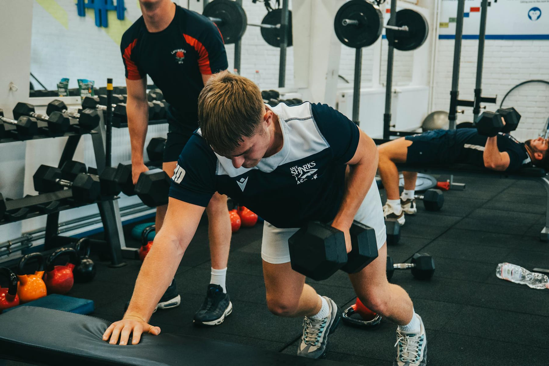 Men lifting dumbbells during a workout session in a gym. Strength and fitness training. on First Rep Forward