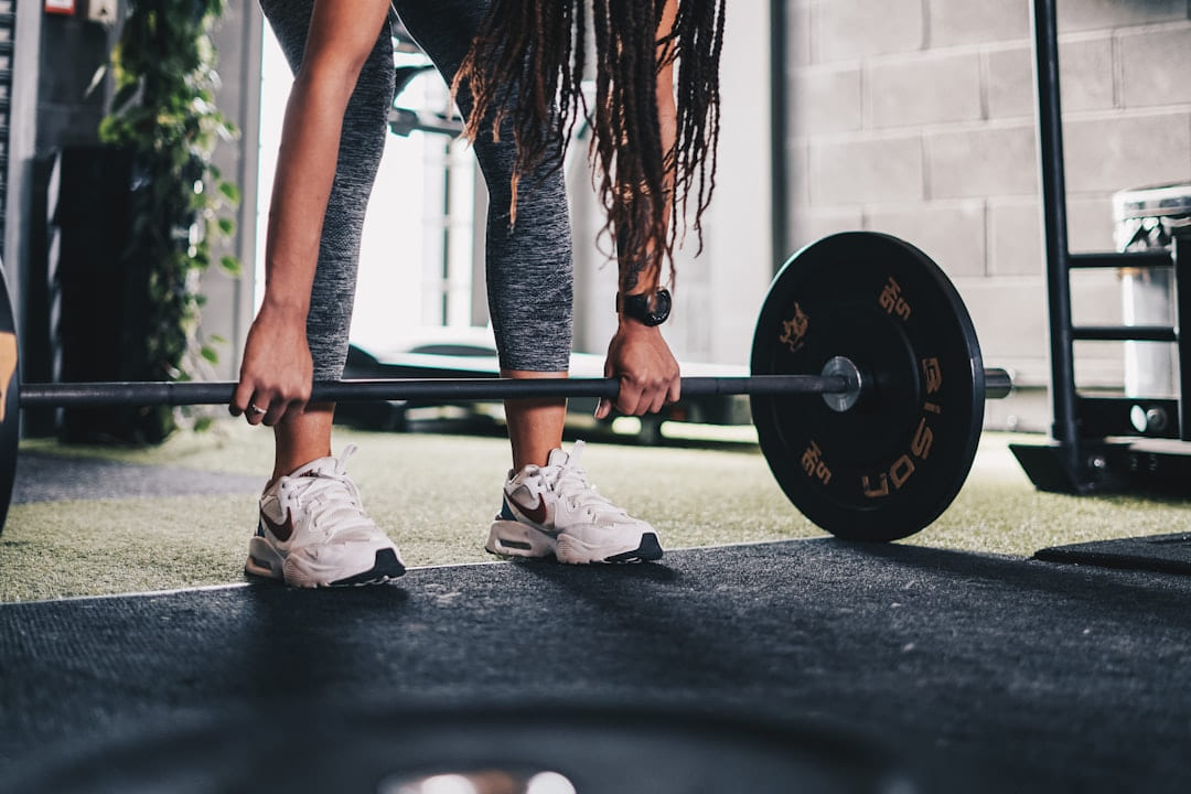 a woman lifting a barbell in a gym on First Rep Forward